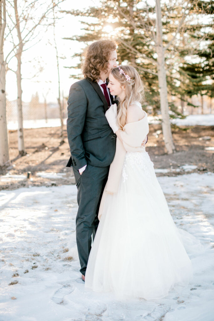 winter bride, bridal hair ideas, white wedding, snowy wedding, bridal hairpiece, couple embracing, wedding outfits