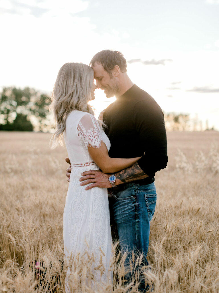 couple in wheat field, riverside engagement, calgary, nicole sarah, sunset engagement photos, fall romance, engagement photography fall, couple cuddling, couple laughing, white dress, white dress engagement, edmonton engagement photographer