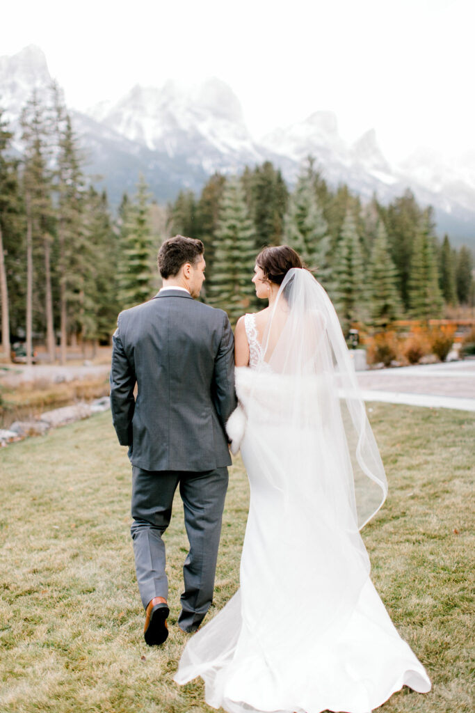 malcolm hotel canmore, malcolm wedding, canmore wedding, mountain wedding, weddings in the rocky mountains, nicole sarah, award winning wedding photography, couple walking mountains, bride groom mountains, bride mountain backdrop, wedding party mountains, groom kissing bride, bride under veil, bride groom kissing
