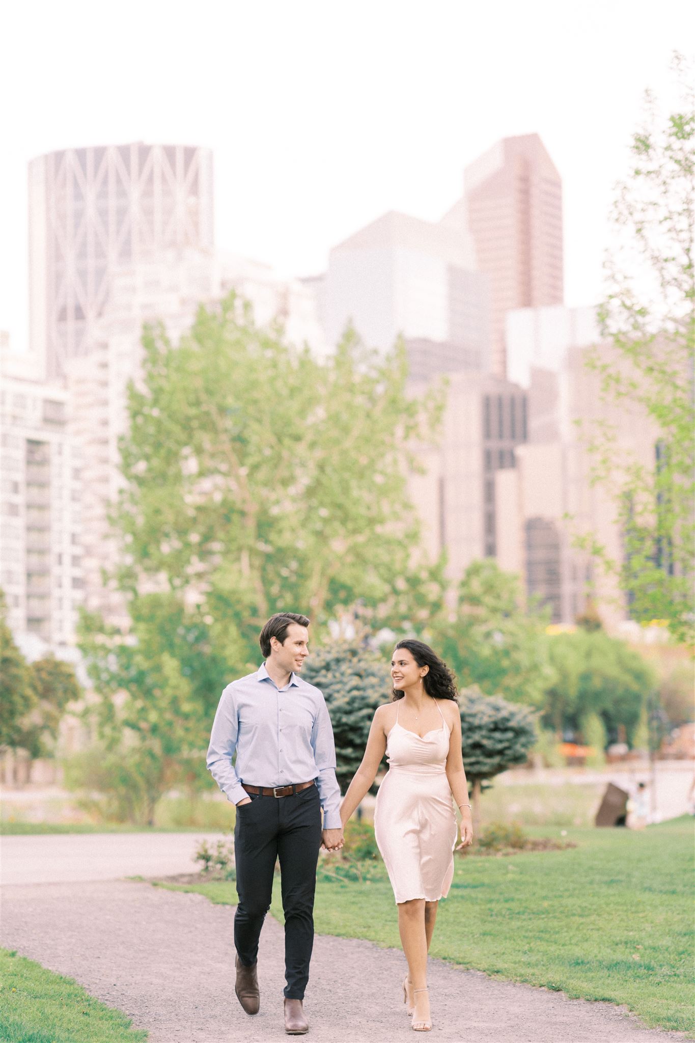 Relaxed Sunset Engagement Downtown Calgary, Cherry blossom engagement photos, cherry blossoms, couple walking downtown, cityscape engagement, couple embracing engagement, nicole sarah