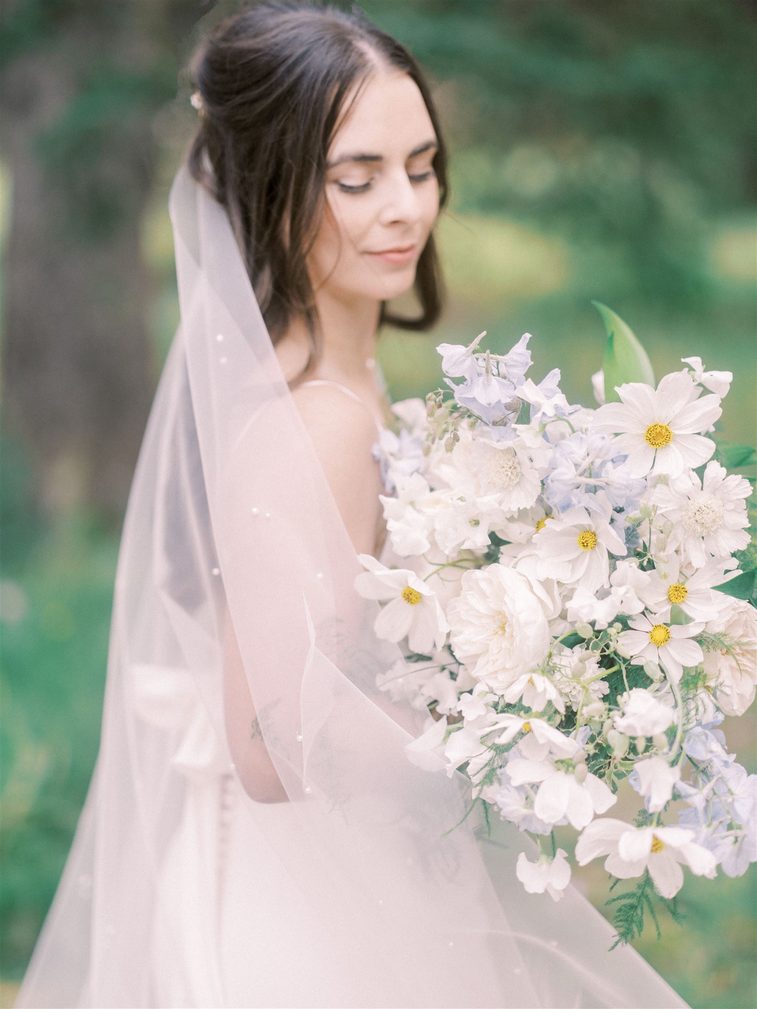10 Wedding Details You Must Have, wedding planning, bride holding bouquet, nicole sarah, calgary wedding planning, bride with veil looking down at flowers, pastel bouquet wedding, large wedding bouquet
