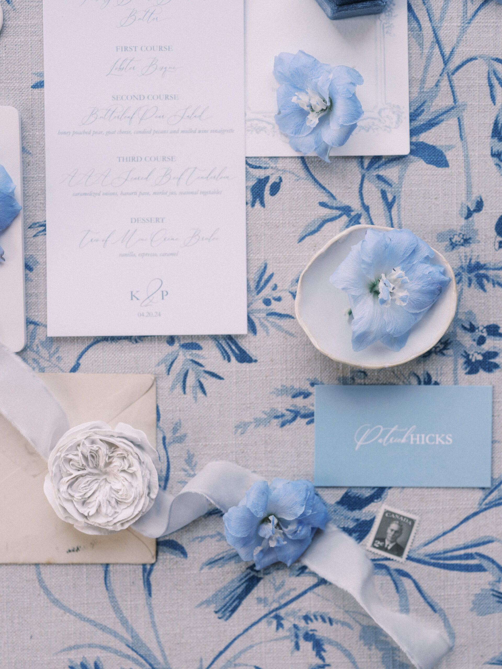 wedding flat lay french blue, wedding ceremony hydrangeas roses, blue tapered candles wedding, gold cutlery, head table florals, bridal table flowers, hydrangea centrepieces, tall hydrangea centrepiece, blue ceremony arch, hydrangea ceremony arch, french wedding, light blue wedding, dusty blue florals, anemones, wedding floral inspo, blue wedding hydrangeas, nicole sarah wedding photography, gold trim wedding plates