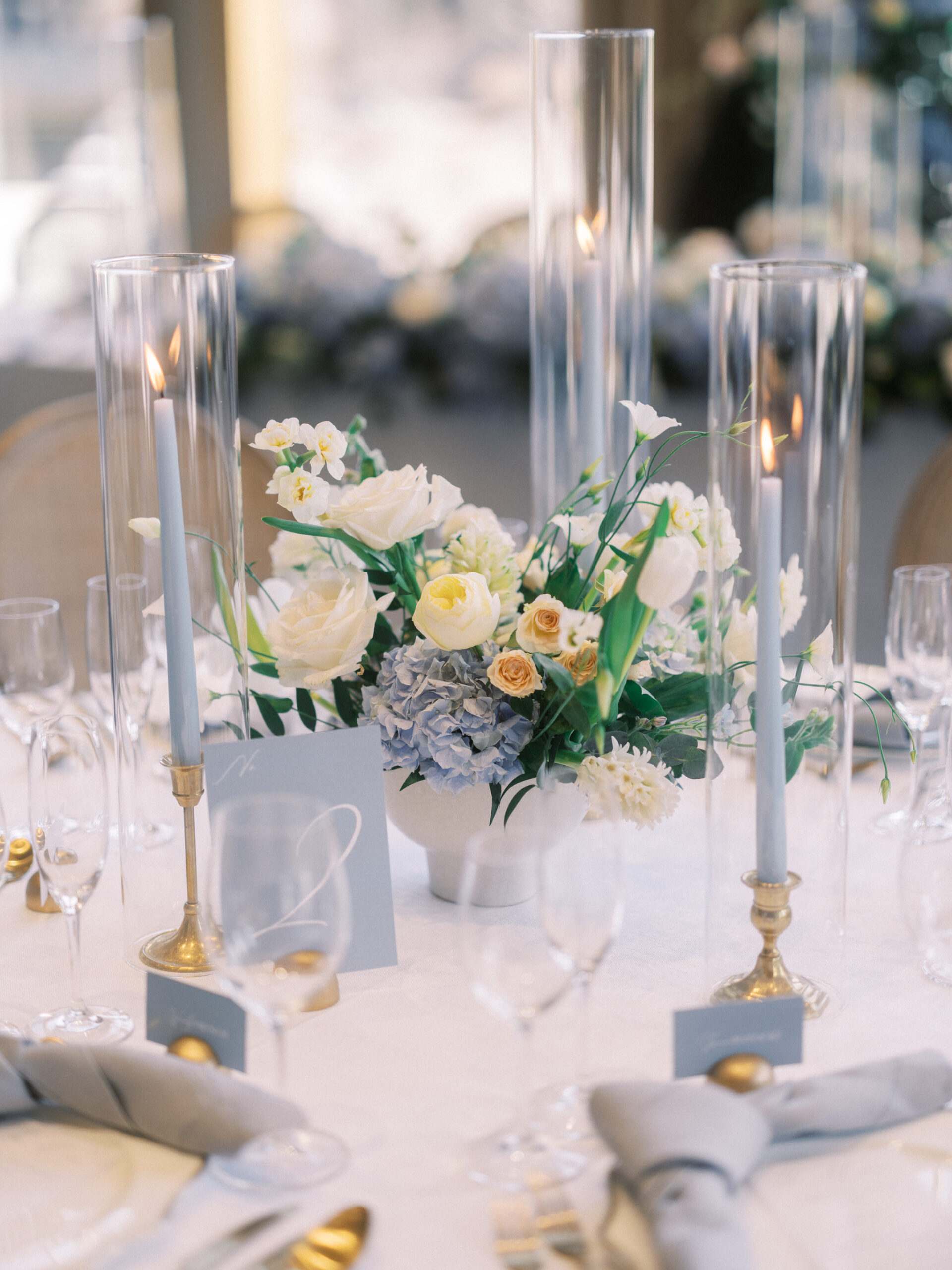 French Blue Parisian Wedding Inspiration, blue tapered candles wedding, gold cutlery, head table florals, bridal table flowers, hydrangea centrepieces, tall hydrangea centrepiece, blue ceremony arch, hydrangea ceremony arch, french wedding, light blue wedding, dusty blue florals, anemones, wedding floral inspo, blue wedding hydrangeas, nicole sarah wedding photography, gold trim wedding plates