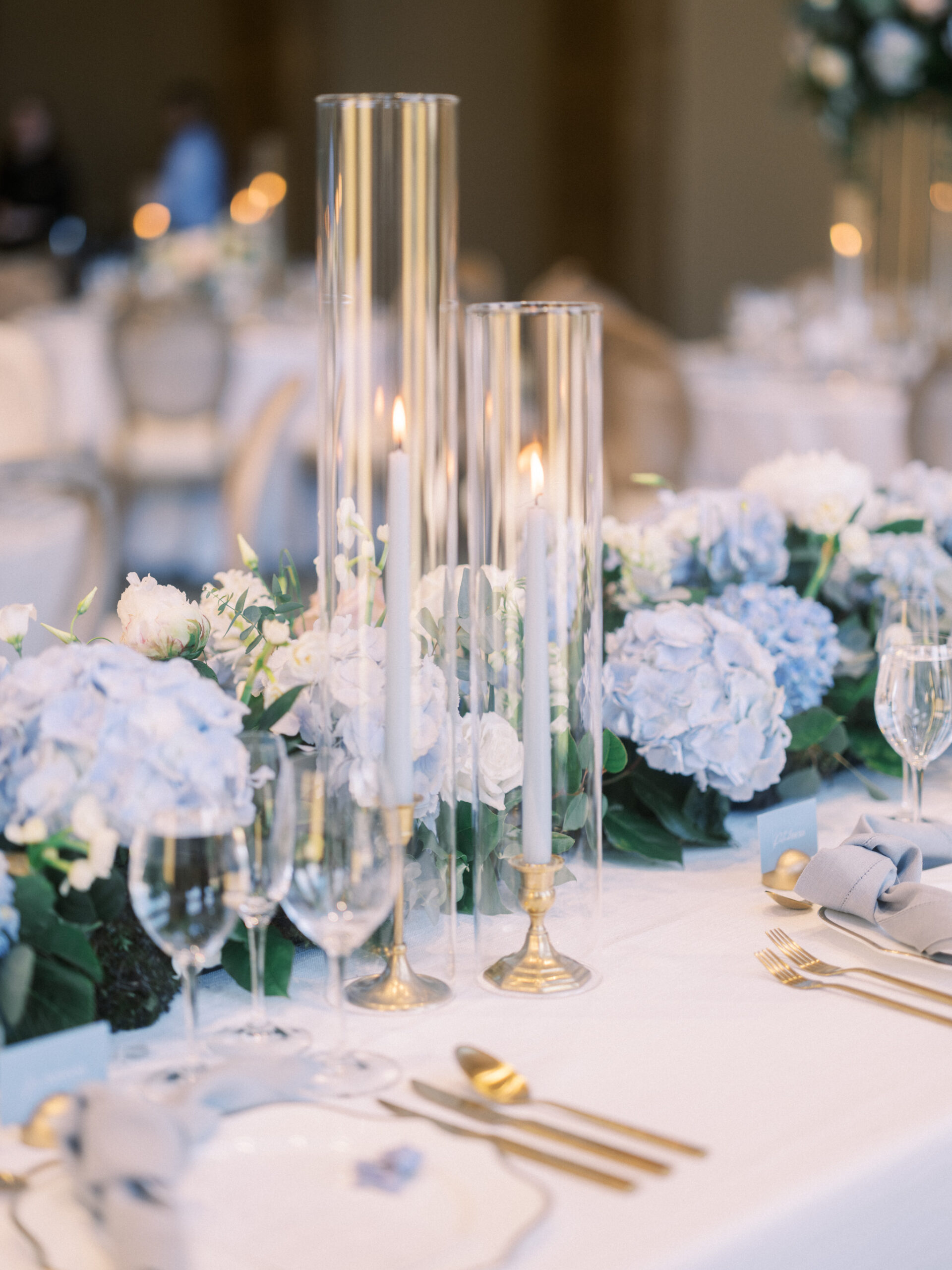French Blue Parisian Wedding Inspiration, blue tapered candles wedding, gold cutlery, head table florals, bridal table flowers, hydrangea centrepieces, tall hydrangea centrepiece, blue ceremony arch, hydrangea ceremony arch, french wedding, light blue wedding, dusty blue florals, anemones, wedding floral inspo, blue wedding hydrangeas, nicole sarah