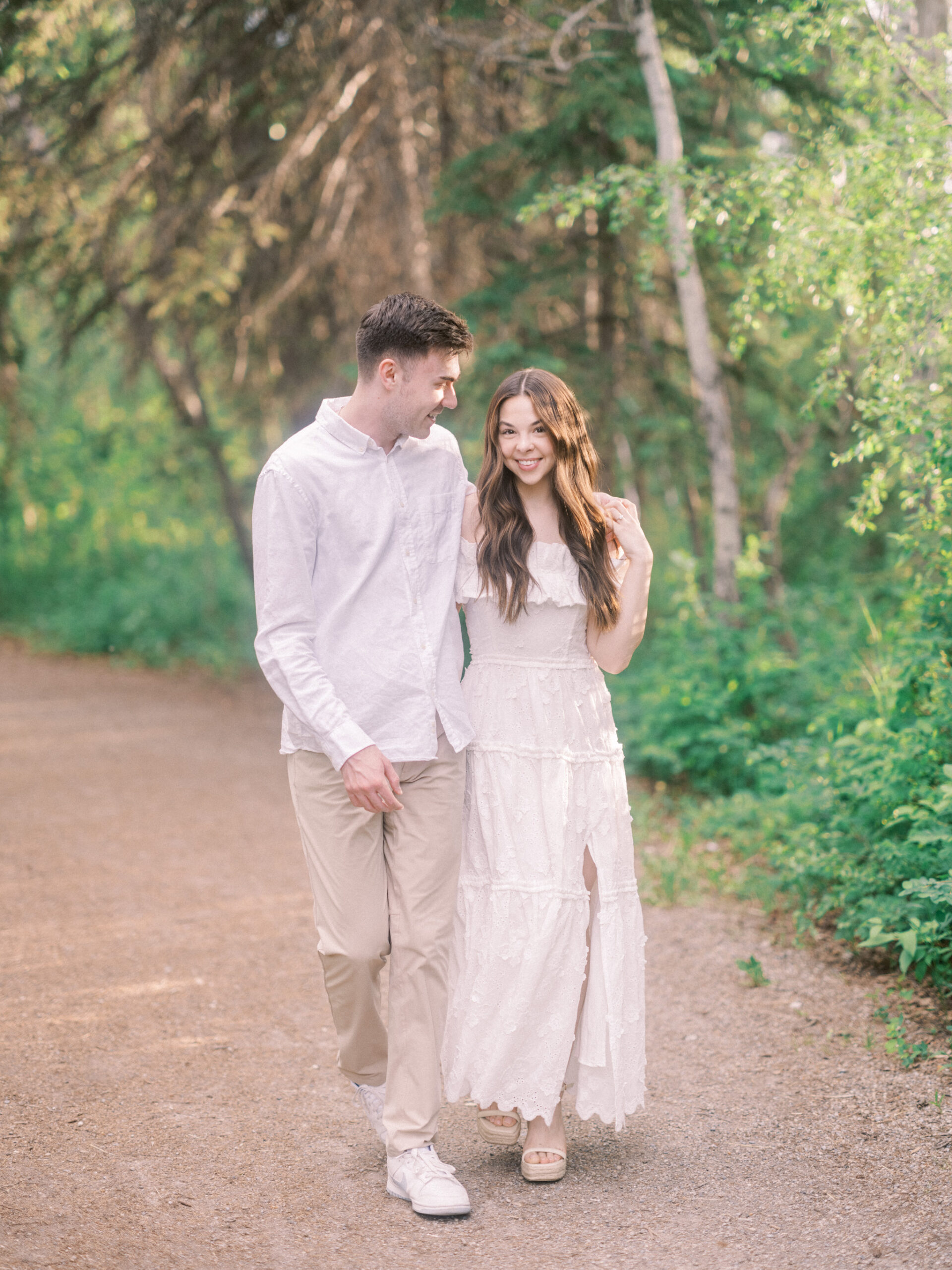 Riverside calgary engagement, forest engagement, bride in white ruffled dress engagement, groom and bride sitting by the river, bride and groom standing in river, standing in sunset forest, nicole sarah, calgary wedding photographers, fish creek park engagement