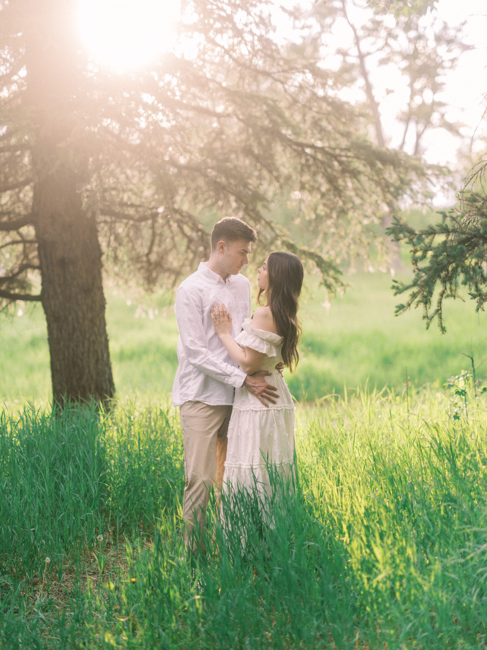 Riverside calgary engagement, forest engagement, bride in white ruffled dress engagement, groom and bride sitting by the river, bride and groom standing in river, standing in sunset forest, nicole sarah, calgary wedding photographers, fish creek park engagement