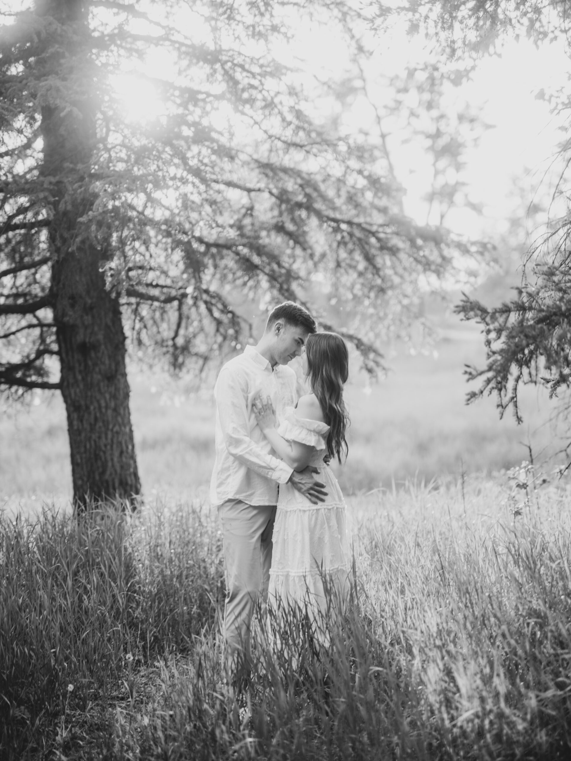 Riverside calgary engagement, forest engagement, bride in white ruffled dress engagement, groom and bride sitting by the river, bride and groom standing in river, standing in sunset forest, nicole sarah, calgary wedding photographers, fish creek park engagement