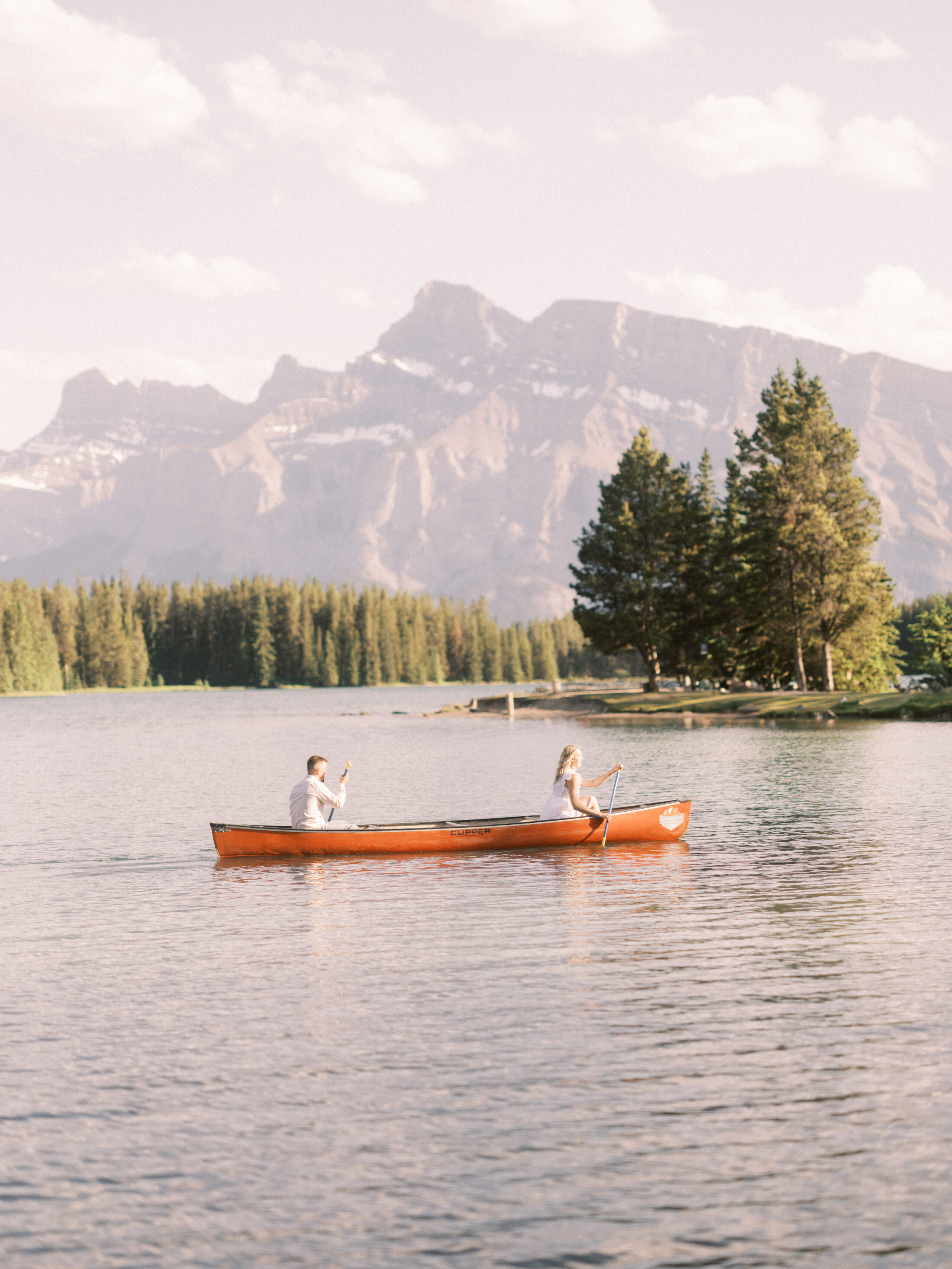 canmore wedding venues, couple in canoe, canoe photo, engagement mountains canoe, couple paddling a canoe in the mountains, two jack lake banff, nicole sarah, calgary wedding photographers