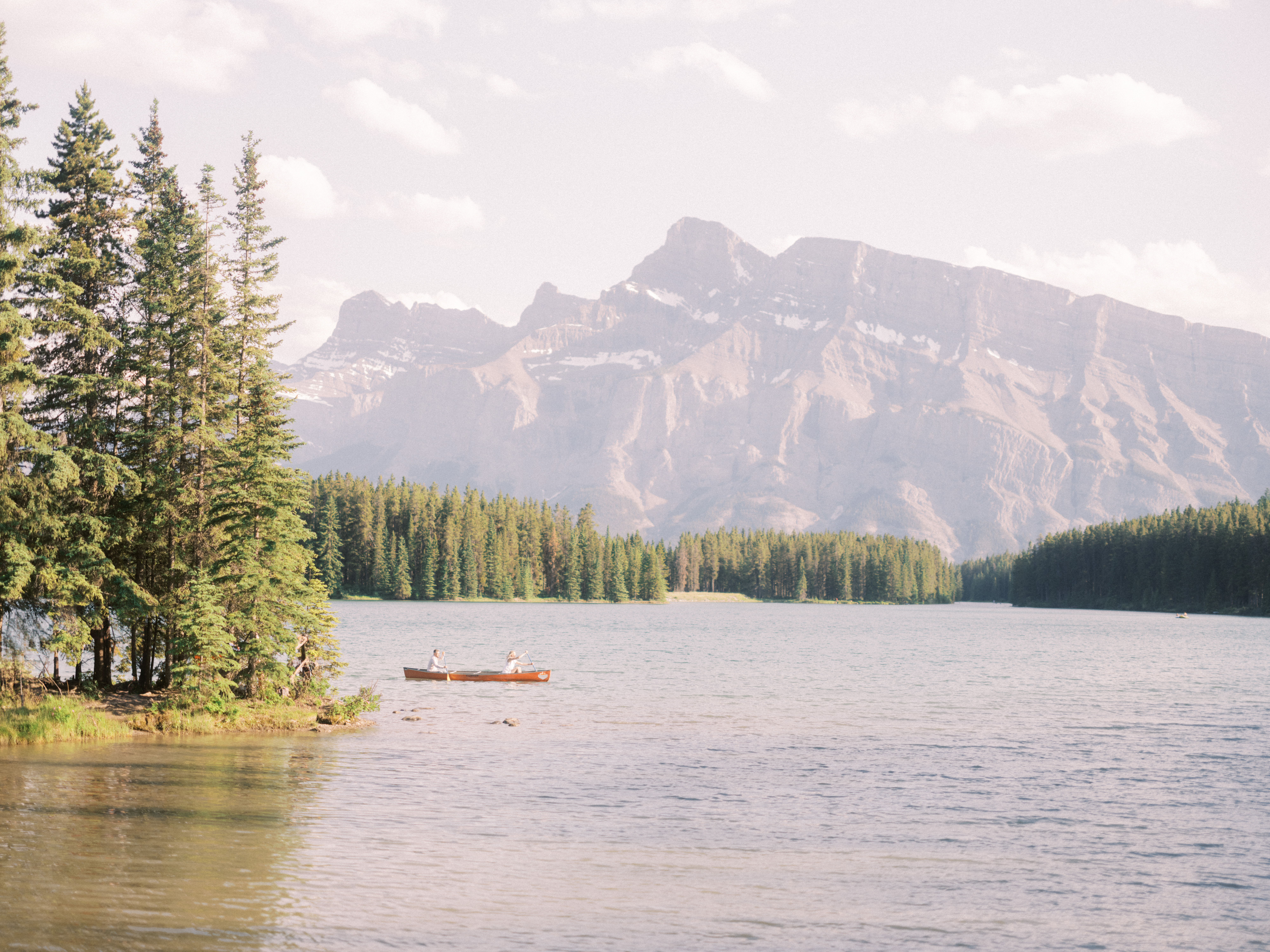 Banff Wedding Photographer, couple canoeing in banff, two jack lake engagement, nicole sarah, calgary wedding photographers, couple in canoe engagement, mountains engagement photos