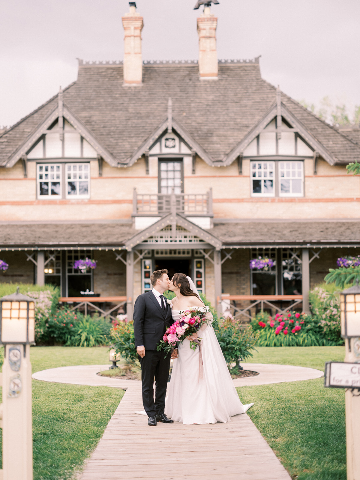 bride and groom kissing in front of heritage building, bow valley ranchehouse wedding, bow valley ranche wedding day, The Ultimate Calgary Wedding Photography Guide: Everything You Need to Know Before Your Wedding